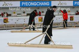10.02.2009, Pyeong Chang, Korea (KOR): Volunteers clean the shooting range - IBU world championships biathlon, training, Pyeong Chang (KOR). www.nordicfocus.com. © Manzoni/NordicFocus. Every downloaded picture is fee-liable.