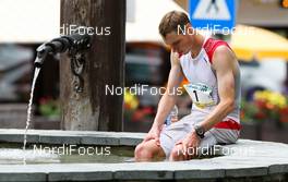 06.07.2011, Ehrwald, Austria (AUT): The winner of the first stage, Tom Owens (SCO) sitting in a fountain after the race  - Salomon 4 Trails, trail running, 38km, Garmisch-Partenkirchen (GER) - Ehrwald (AUT). www.nordicfocus.com. Â© NordicFocus. Every downloaded picture is fee-liable.