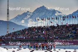 16.02.2014, Sochi, Russia (RUS): athletes pass the crowded cross country stadium - XXII. Olympic Winter Games Sochi 2014, cross-country, 4x10km men, Sochi (RUS). www.nordicfocus.com. © NordicFocus. Every downloaded picture is fee-liable.